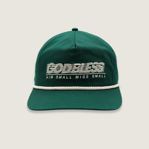 A dark green baseball cap with a white rope detail across the brim and white embroidered text reading 'GODLESS' and 'AIM SMALL MISS SMALL' on the front, shown against a light beige background.
